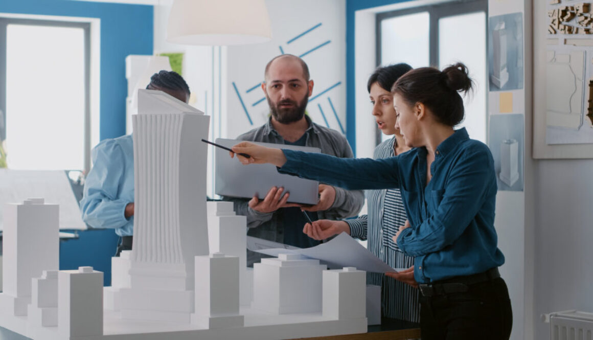 Multi ethnic people working with laptop, tablet and building model for architecture project