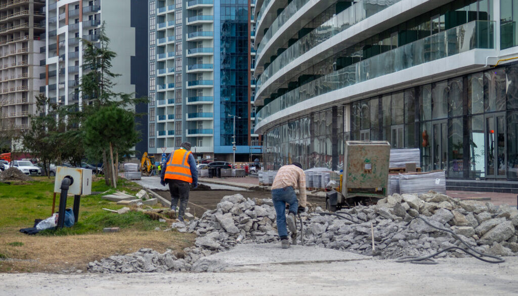 Workers break off concrete. Hard work. People are reconstructing