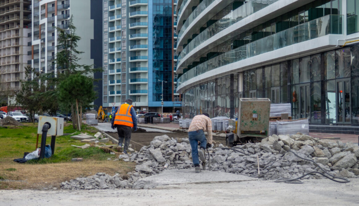 Workers break off concrete. Hard work. People are reconstructing