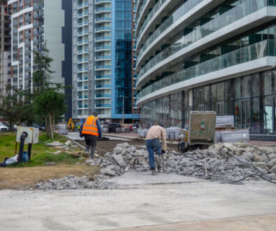 Workers break off concrete. Hard work. People are reconstructing